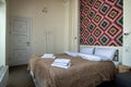 Interior of a spacious hotel bedroom with fresh linen on a big double bed. Cozy contemporary room in a modern house Royalty Free Stock Photo