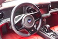 Interior of a sports car Marussia B1 of red color with elegant leather seats, low seating position and steering wheel of a