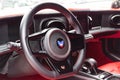 Interior of a sports car Marussia B1 of red color with elegant leather seats, low seating position and steering wheel of a