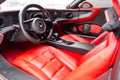 Interior of a sports car Marussia B1 of red color with elegant leather seats, low seating position and steering wheel of a