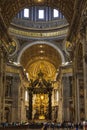 The interior of St. Peter`s Basilica in the Vatican. Baroque canopy over the altar, above the canopy rises a Department dedicated Royalty Free Stock Photo
