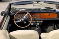 Interior with steering wheel and dash of a Seventies convertible Fiat sports car.