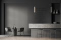 Interior of stylish coffee shop with gray walls, concrete floor, massive gray bar counter with stools, shelves with dishes and