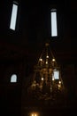 Interior of temple. Antique chandelier. Windows in dark. Lighting in church