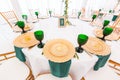 Interior of tent for wedding dinner, ready for guests. Served round banquet table. Golden dishes, green wine glasses and Royalty Free Stock Photo