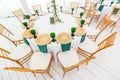 Interior of tent for wedding dinner, ready for guests. Served round banquet table. Golden dishes, green wine glasses and Royalty Free Stock Photo