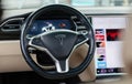 Interior of a Tesla vehicle in a tan and black leather finish.