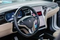 Interior of a Tesla vehicle in a tan and black leather finish.