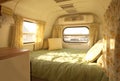 Interior of a tiny camper van with bed and small kitchen. Generative AI