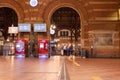 Interior of a train station with red brick arched walls and a bustling atmosphere. Copenhagen