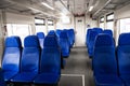 The interior of the transfer train to the airport. Rows of blue armchairs. Without people