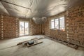 Interior of unfinished brick house with concrete floor and bare walls ready for plastering under construction. Real estate