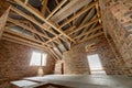 Interior of unfinished brick house with concrete floor, bare walls ready for plastering and wooden roofing frame attic under