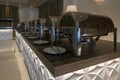 Interior view of a catering room buffet party ready to welcome people for a wedding or celebration event. Chafing dish. Plates and