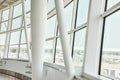Interior view of curved windows with thick white beams overlooking blown out airport exterior