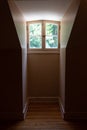 Interior view of a dormer window and very narrow opening in a darkened room
