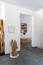 Interior view of an elegant foyer with black tile floor and white plaster walls and wooden furniture and decorative articles