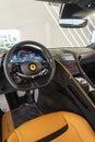Interior view of a Ferrari Roma with a dashboard, digital gauge cluster, and orange leather seats Royalty Free Stock Photo