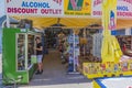 Interior view of little boutique. Young worker replenishes shelves with beverages. Rhodes.