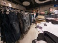 Interior view of a mister lady clothing store with customer in Austria. View of different clothing hanging in a modern shop