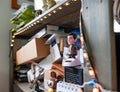 Interior view of an office workspace showing clutter as seen on a wooden bookshelf.