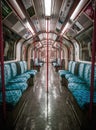 Interior view of a passenger train featuring blue seating, black flooring, and red accents. Royalty Free Stock Photo