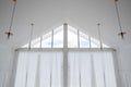 Interior view of triangle shape window with white curtain and cloud sky Royalty Free Stock Photo