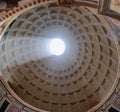 Interior view upward to the coffered concrete dome of Roman Pantheon with famous sunbeam and circular opening oculus in Royalty Free Stock Photo