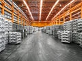 Interior view of a warehouse full of aluminum ingot stacked in row. Industrial raw material storing and warehousing.