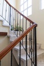 Interior white gray stone Stairs with metal forged railing to second floor of house with windows Royalty Free Stock Photo