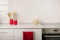 Interior white kitchen with kitchen tools and red crockery. Royalty Free Stock Photo