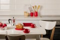 Interior white kitchen with kitchen tools and red crockery. Royalty Free Stock Photo