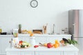 interior of white light kitchen with delicious fruits and vegetables