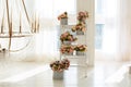 Interior white living room with Bouquets of flowers in round boxes on ladder. Wedding decor. Beautiful large chandelier with candl Royalty Free Stock Photo