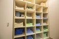 Interior of white plastic cabinet or clothing open wardrobe with stacked piles of clean colorful linen on shelves. Furniture Royalty Free Stock Photo