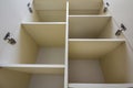 Interior of white plastic cabinet or clothing wardrobe with many empty shelves with open doors. Furniture design and installation