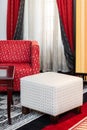 Interior with white pouffe and red sofa