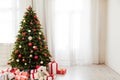 Christmas interior of the white room green Christmas tree with red gifts for the new year decor winter holiday Royalty Free Stock Photo