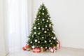 Christmas interior of the white room green Christmas tree with red gifts for the new year decor winter holiday Royalty Free Stock Photo