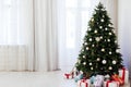 Christmas interior of the white room green Christmas tree with red gifts for the new year decor winter holiday Royalty Free Stock Photo