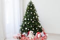 Christmas interior of the white room green Christmas tree with red gifts for the new year decor winter holiday Royalty Free Stock Photo