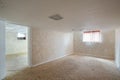 Interiors of an empty room of a house with white walls and an old dirty carpet on the floor