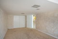 Interiors of an empty room of a house with white walls and an old dirty carpet on the floor