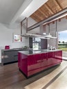 Interiors of a modern red lacquered kitchen in the foreground the island kitchen