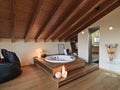 Interiors shots of a modern bathroom in the attic room in the foreground the wirlpool bathtub on the two wooden steps instead the Royalty Free Stock Photo