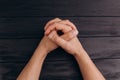 Interlocked fingers, white male hands interlocked on black rustic wood table close up. top view. a man is waiting for negotiations Royalty Free Stock Photo