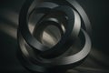 Interlocking black metal rings illuminated dramatically creating a complex sculptural form with deep shadows and modern artistic Royalty Free Stock Photo