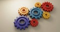 Interlocking, colorful gears in various sizes are arranged on a light surface. The
