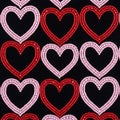 Interlocking heart shapes are created using small beads on a black background, Royalty Free Stock Photo
