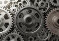 Interlocking metallic gears of various sizes create a complex, mechanical design. The gears are Royalty Free Stock Photo